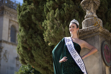 Young, pretty, blonde woman in green party dress with sequins, diamond crown and beauty pageant...