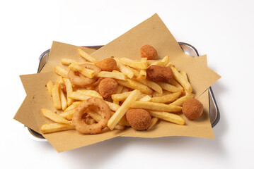 mixed fried food on a metal baking tray with fried potatoes, onions and olives isolated on a white background