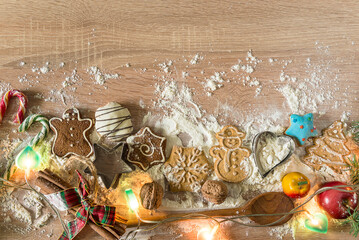 Christmas holiday cookie making; gingerbread cookies, wooden spoon, fruit, flour on a wooden...