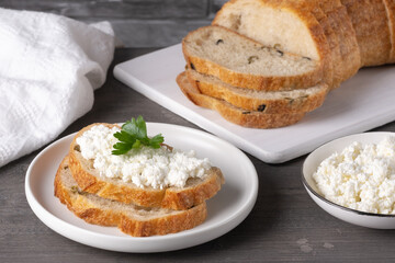 Bread with curd cheese on wooden board