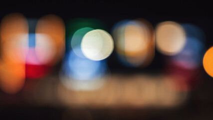 blurred background with multicolored bokeh in night city on street