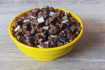 Granola with oatmeal and chocolate in a yellow bowl