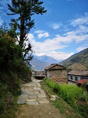 Fototapeta na wymiar A winding stone path emerges from the rugged mountains, guiding visitors to a village nestled in nature's embrace.