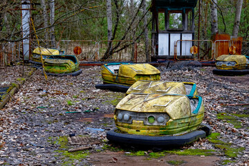 An old, dilapidated bumper car with peeling paint, showing signs of neglect and decay.