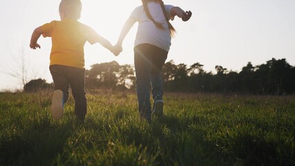 happy family. happy family childhood dream concept. children silhouette hold hands run through the grass in the park in the summer at sunset. baby children run at sunset fun