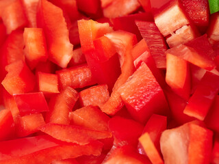 Vegetables cut into squares in a kitchen. Green, red pepper, carrot and leek