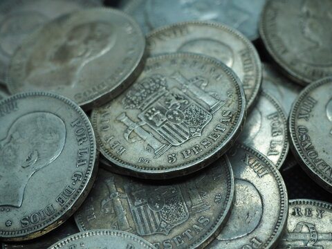 Silver 5 pesetas coins, duros, on a black background