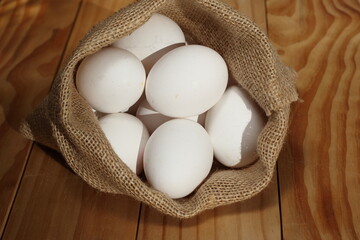 eggs in a burlap sack on wooden background