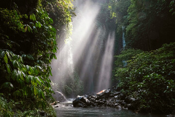 View of a creek leading to Hidden waterfall Sekumpul and sun beams. Bali, Indonesia.