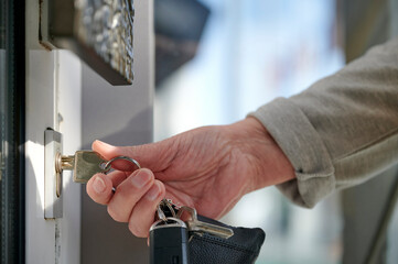 Hand einer Seniorin schlie&szlig;t eine Haust&uuml;r auf
