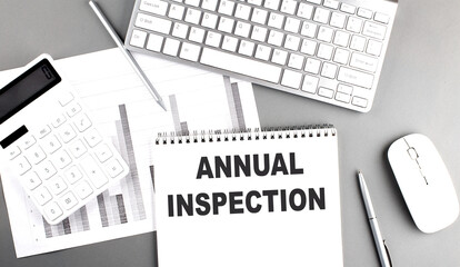 ANNUAL INSPECTION text on a notebook with chart and keyboard business concept