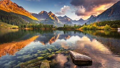 awesome nature landscape beautiful scene with high tatra mountain peaks stones in mountain lake calm lake water reflection colorful sunset sky amazing nature background autumn adventure hiking