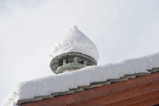 Tetto dello chalet in montagna con la neve sul comignolo