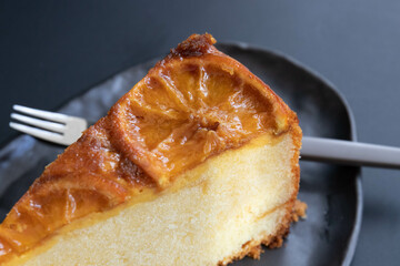A slice of Vanilla cake topped with candied Orange