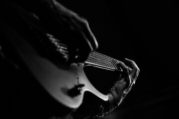 Nahaufnahme einer E-Gitarre bei einem Konzert in Swarz-Weiß