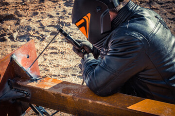 Welder works with metal, robot welder