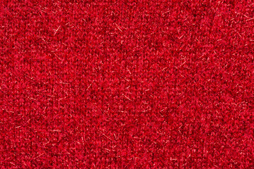 Red sweater fabric with shiny particles. Christmas background or cover