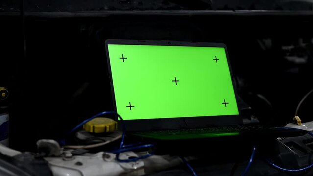 A specialist auto mechanic uses a computer laptop to diagnose and inspect a car. The technician inspects the car to find broken components and errors in the car's control unit databases. Auto Mechanic