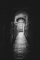 Dark and empty corridor of medieval castle. Black and white image.