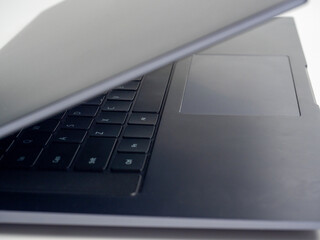 Close-up of a slightly open laptop cover in gray on a light background