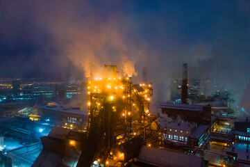 Night top view of steel plant at night with smokestacks and fire blazing out of the pipe....