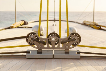 Part of the teak deck of a sailing yacht with fasteners on it for fixing ropes.