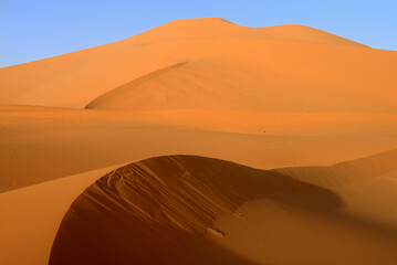 SAND DUNES AND ROCK FORMATIONS IN THE REGION OF TADRART ROUGE IN THE SAHARA DESERT IN ALGERIA