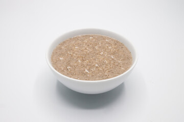Bowl with tasty oatmeal on white Background