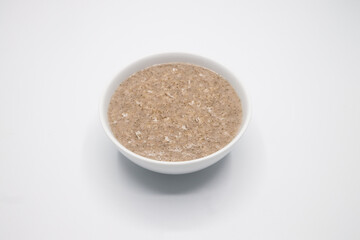 Bowl with tasty oatmeal on white Background