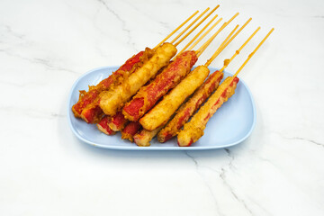 The delicious fried Crab sticks mixed with flour and seasonings on dish with marble background. Fried meatballs Made from meat. Asian Street Food. Deep fried Crab sticks meatballs on blue plate.