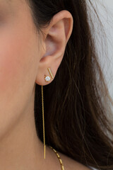 Woman wearing beautiful dangly and stud earrings with zirconia.