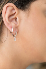 Young woman wearing silver clear sweet drop earrings.