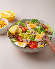 Fresh salad of tuna, egg, lettuce, cherry tomatoes, corn and lemon. Dietary, complete bowl of salad.