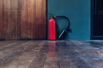 Fire extinguisher in the operating department . Install a fire extinguisher on the floor in building. Dry chemical powder fire extinguisher in corridor .a red fire-extinguisher hangs on floor - obrazy, fototapety, plakaty