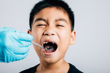 In a pediatric dentist's practice a doctor examines a child's mouth after extraction of a loose...