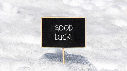Good luck symbol. Concept words Good luck on beautiful black chalk blackboard. Beautiful white snow...