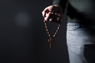 a man holding a Christian cross on his hand - obrazy, fototapety, plakaty