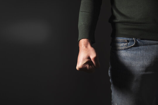 angry man fist on black wall background
