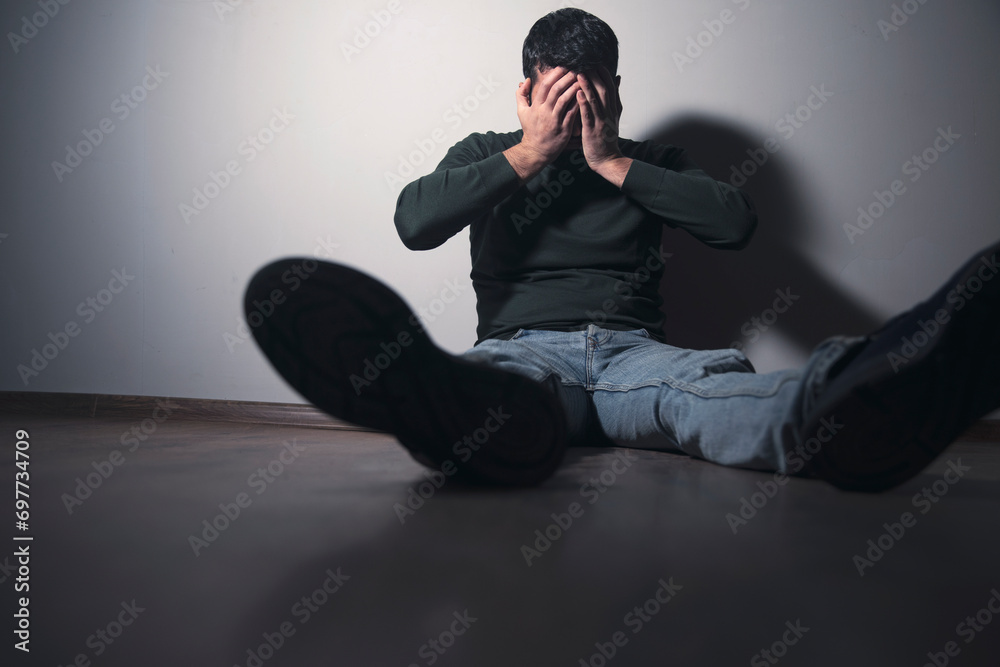 Wall mural sad man sitting hand in face