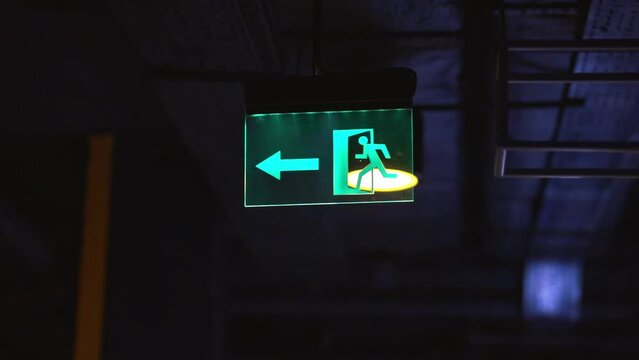 Exit icon, close-up. Direction to the emergency exit. a green light sign indicating the direction of movement to the emergency exit in the room. green emergency exit sign above a door in a interior.