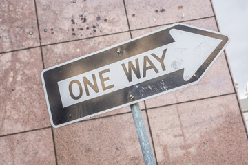 One way road sign with blurred wall background