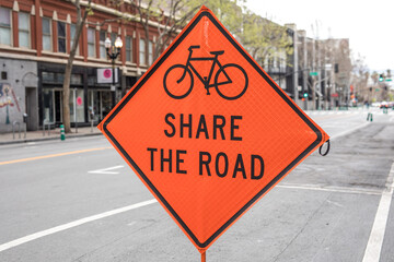 Bicycle and car share warning sign on the road work zone