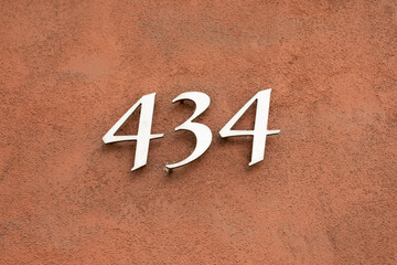 434 number on the brown wall
