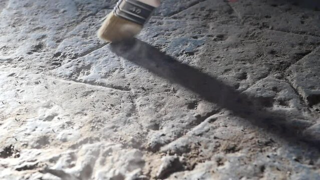 Close-up of an ancient image of the six-pointed Star of David on a stone slab; an archaeologist's brush sweeps away dust from an Ancient Jewish symbol in slow motion. Israeli territory