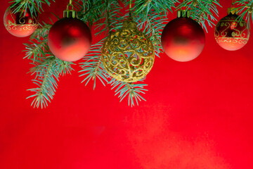 Christmas background. Festively decorated fir branches on a red background.