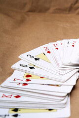 Shuffling of poker cards spread out on a cardboard-like surface.