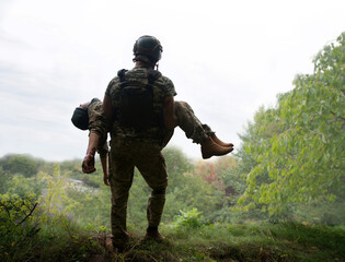 The commander carries a wounded soldier