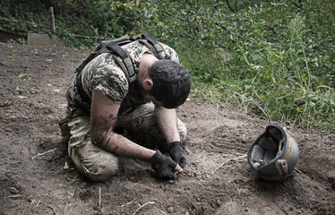 Sad soldier sits on the ground