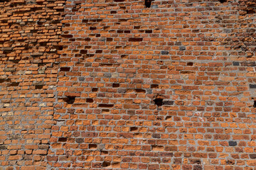 Fototapeta na wymiar antique wall made of broken and cracked red bricks