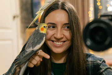 Parrots are sitting on a hand.A girl with birds.Cockatiel parrots of different colors.The owner of...